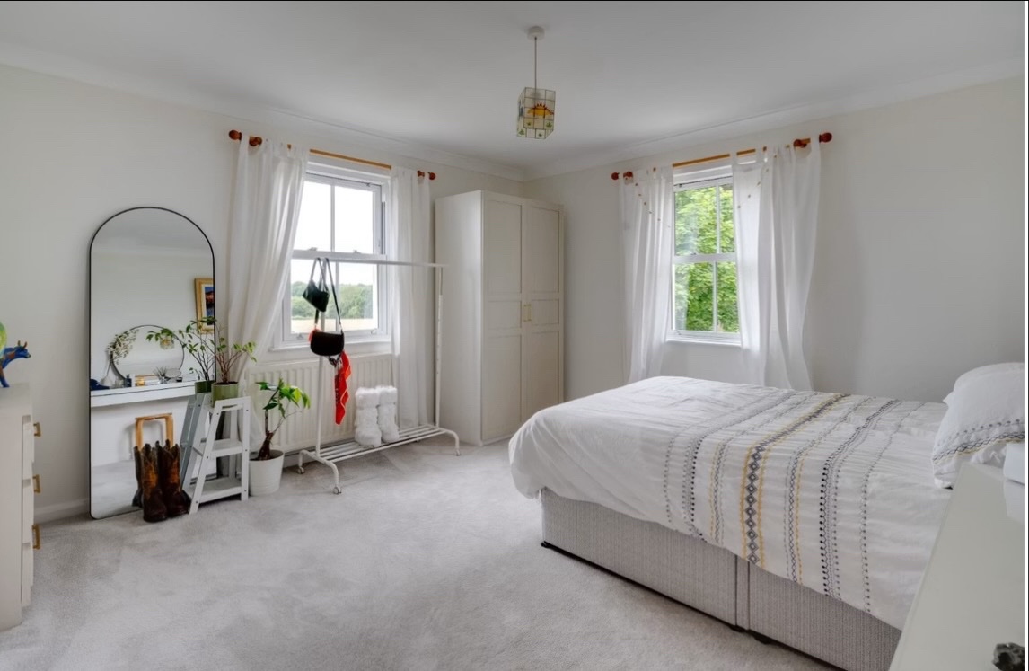 Bright bedroom with arched mirror and soft linens