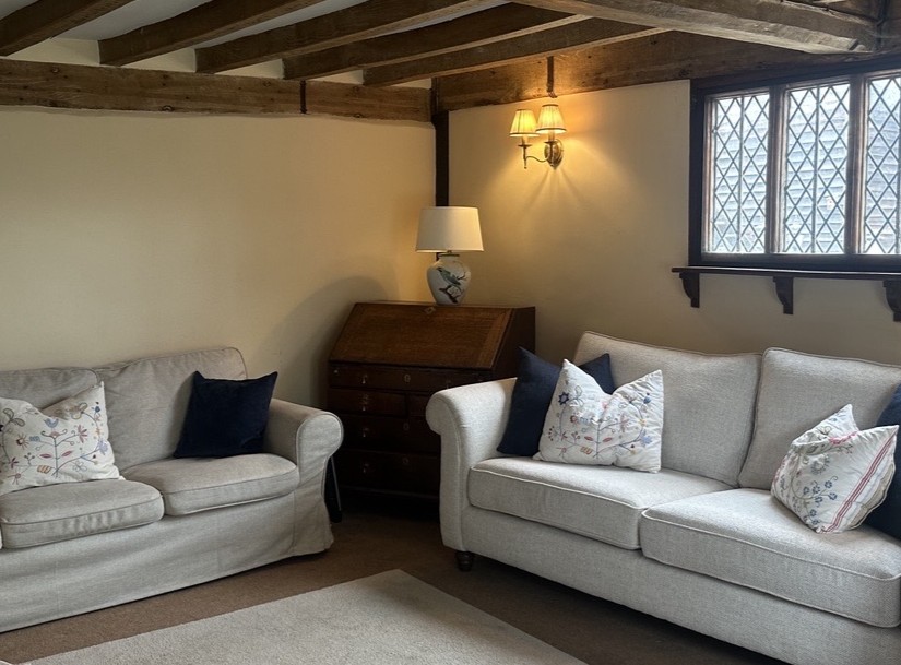 Beamed sitting room with soft neutral sofas